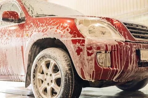 At the sink, the foam flows down and drips from the car onto the floor of the Stock Photos