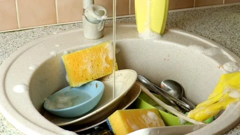 Sink full of dirty dishes, cups, pans and cutlery that need to be washed Stock Footage 232852984