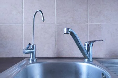 Sink in the kitchen with two taps - one for drinking filtered water Stock Photos