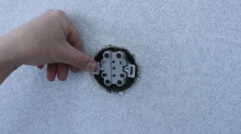 Sinking the base of the double socket into the wall opening Stock Photos
