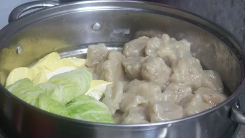 Siomay and cabbage vegetables being steamed in a stainless steel steamer pan Stock Footage 327191615