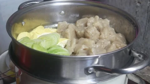 Siomay and cabbage vegetables being steamed in a stainless steel steamer pan Stock Footage 327191667