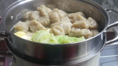Siomay and cabbage vegetables being steamed in a stainless steel steamer pan Stock Footage 327191670