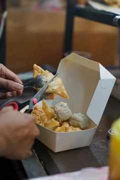Siomay batagor is being cut using scissors, ready to be wrapped Stock Photos