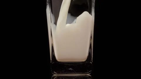 Sip cool. Super slow motion shot of pouring, splashing fresh milk into a Video stock 147412333