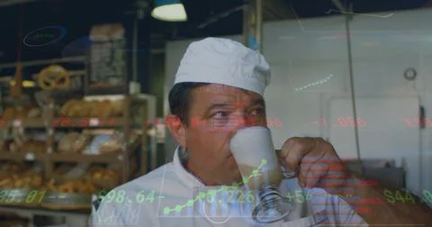 Sipping baker in white coat, cap pausing in bakery, with glass latte, bread Stock Photos