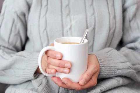 Sipping hot cup of coffee on the couch Stock Photos