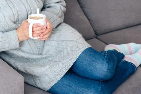 Sipping hot cup of coffee on the couch Stock Photos