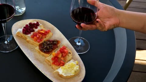Sipping wine paired with small bites, Enjoying appetizers alongside Stock Footage 288905014