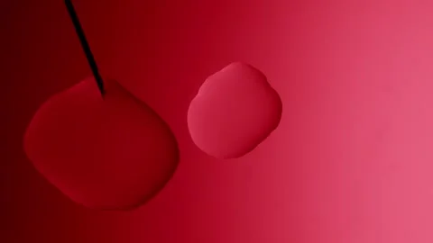 The siringe forms a drop and it connects with anotner on a red background 스톡 동영상 303060972