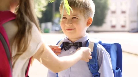  The sister corrects the bow tie to her younger brother. Children at school.  Stock Footage 78912814