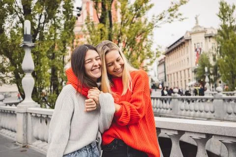 Sister hugging while walking on the city streets, having a day off to spend Stock Photos