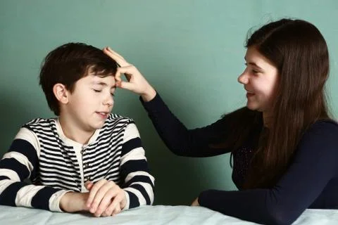 Sister make forehead flip snap ckickto her brother Stock Photos
