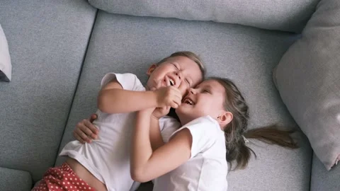 Sister tickles brother while lying on the couch. Stock Footage 150509915