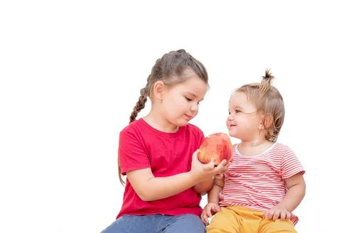 Sisters with apple Stock Photos