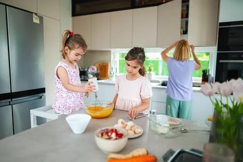 Sisters baking together in a bright kitchen at home Stock Photos
