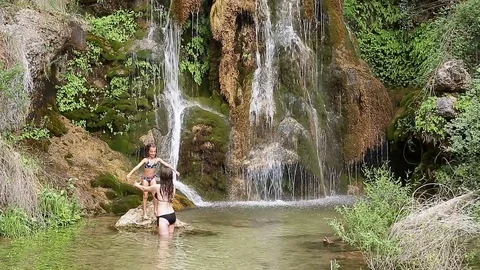 Sisters bathing under a waterfall Stock Footage 80222676