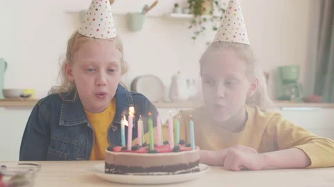 Sisters Blowing out Candles on Cake | Stock Video | Pond5