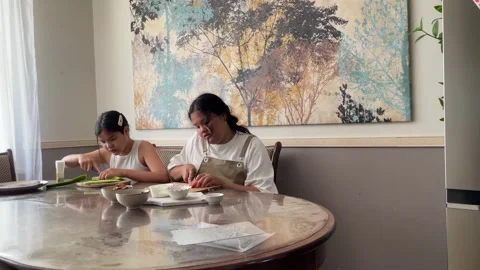Sisters engaged in cooking at home, emphasizing the joy and value of homemade 動画素材 279923476