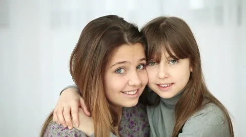 Sisters hugging and looking at camera Stock Footage 10717255