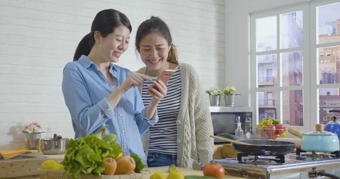 Sisters laughing during prepare breakfast Stock Footage 124103786
