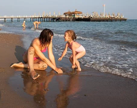 The sisters play on the beach. Stock Photos