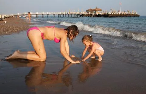 The sisters play on the beach. Stock Photos