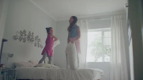 Sisters playing and jumping on the bed Stock Footage 279727526