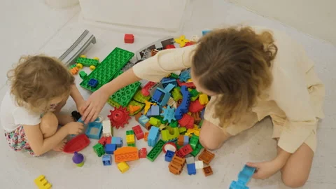 Sisters playing with colorful block constructor Vídeos de archivo 335425204