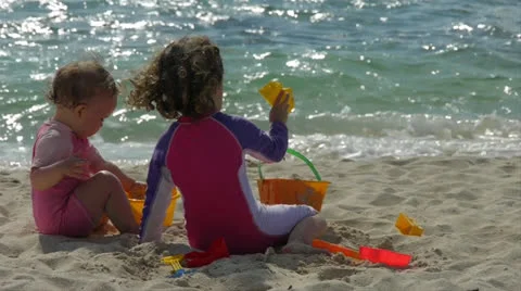 Sisters playing in the sand Stockbeeldmateriaal 22931030
