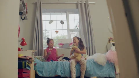 Sisters playing with a teddy bear in their room Stock Footage 279728243