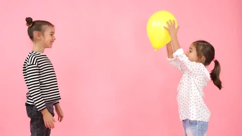 Sisters playing with a yellow balloon. Stock Footage 154168035