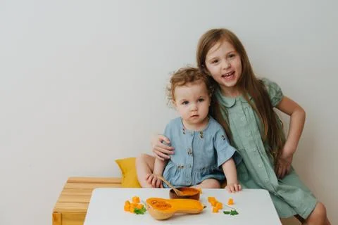 Sisters posing at the table with pumpkin Foto stock