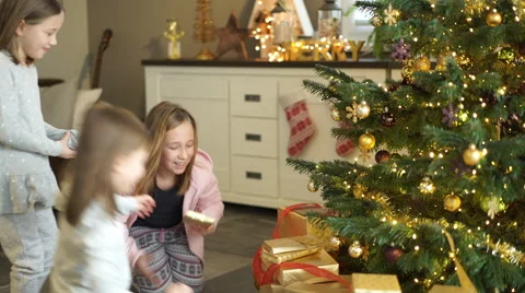 Sisters with presents at christmas tree Stock Footage 58631628