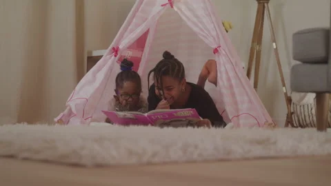 Sisters Reading Together In Tee Pee Stock Footage 208785171