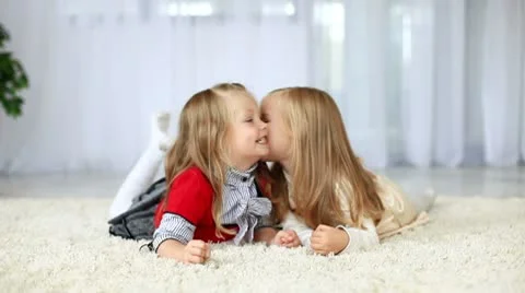 Sisters smiling while lying on the carpet. DOLLY HD Stock Footage 8956849