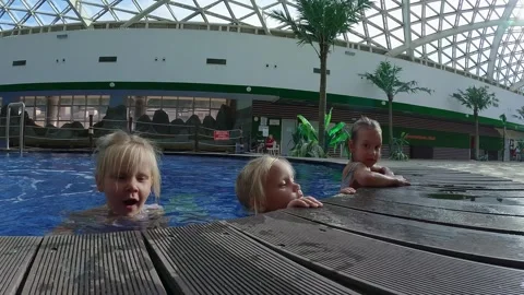 Sisters triplets hold on to the edge of the pool Video stock 255897361