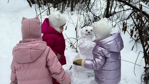 Sisters triplets making a snowman in the forest 库存影片 264114615