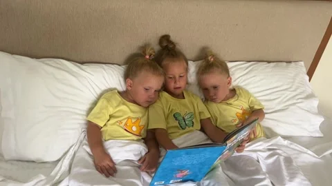 Sister's triplets playing on the bed 库存影片 244008524