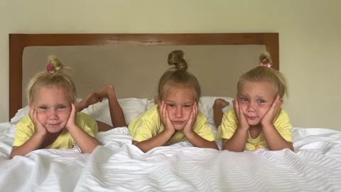 Sister's triplets playing on the bed 库存影片 244008550