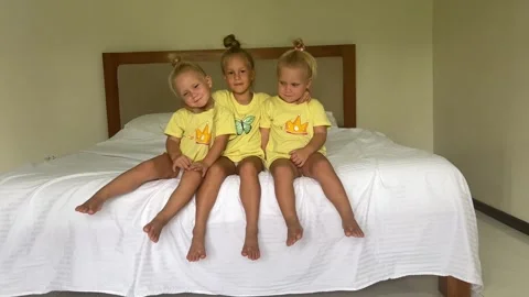 Sister's triplets playing on the bed 库存影片 244008576