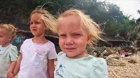 The sister's triplets stand in the wind and look ahead Video stock 245517937