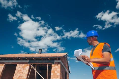 Site construction architect overseeing construction new building with a 库存照片