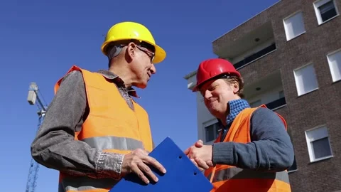 Site Engineer and Supervisor Reviewing Blueprint at Construction Site Stock Footage 306216357
