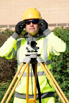 Site engineer checking levels of the road using autolevel Stock Photos