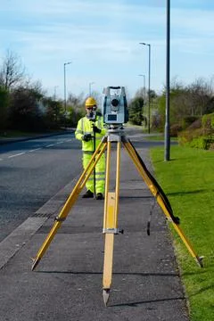 Site engineer checking levels of the road using autolevel 写真素材