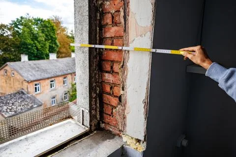 Site inspector measuring window opening during renovation Stock Photos