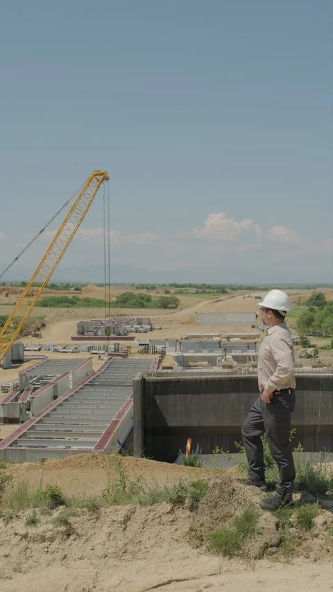 Site manager in hard hat overseeing highway viaduct construction after chec.. Stock Footage 338008800