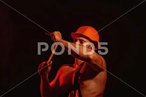 Site is under construction. Man work with hammer. Muscular man builder at work Stock Photos