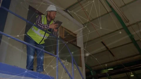 Site worker leaning on rail tapping tablet activating network overlay around him Stock Footage 333833762